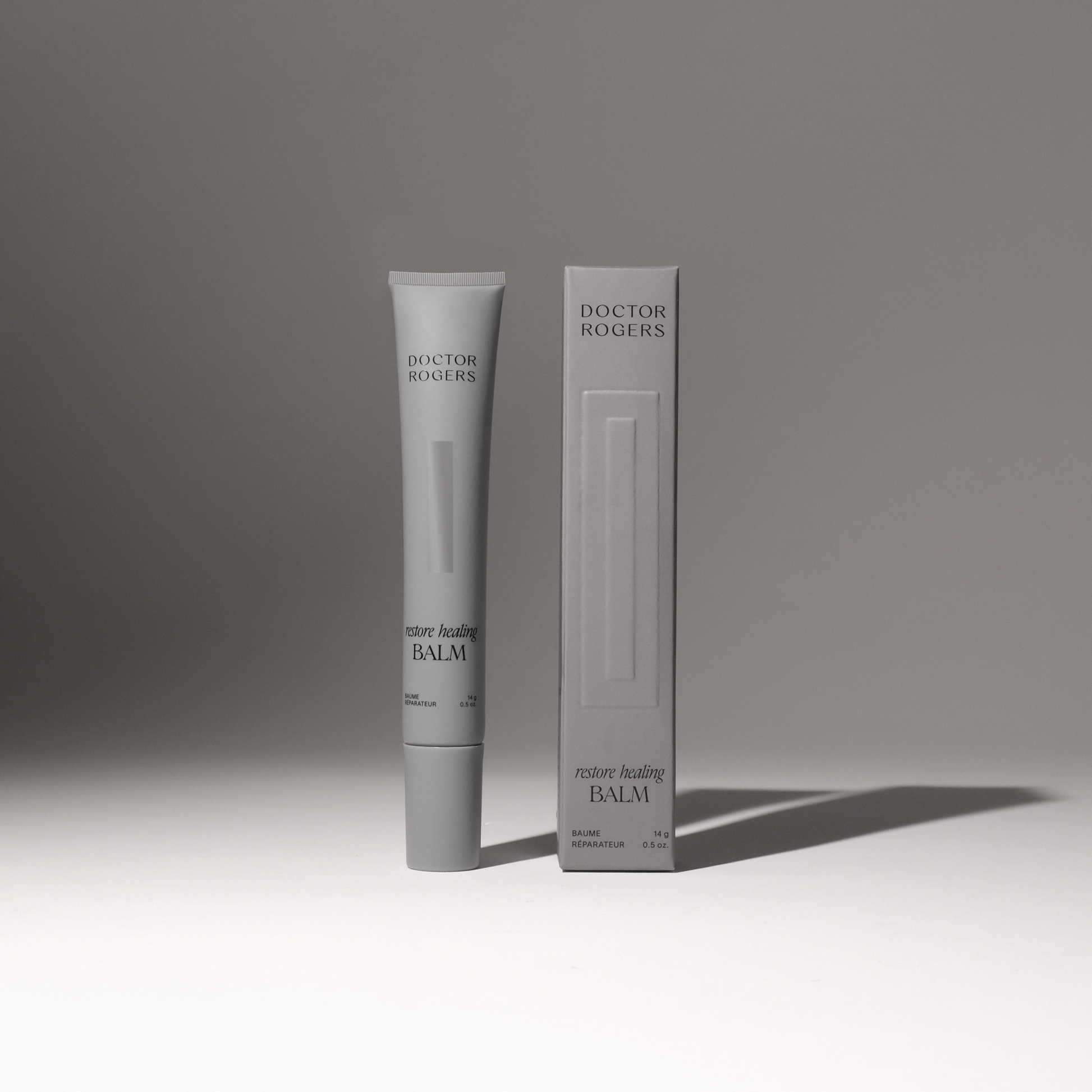 Soothing, natural Restore Healing Balm for eczema and sensitive skin relief in a 0.5 oz tube next to its recyclable packaging. 