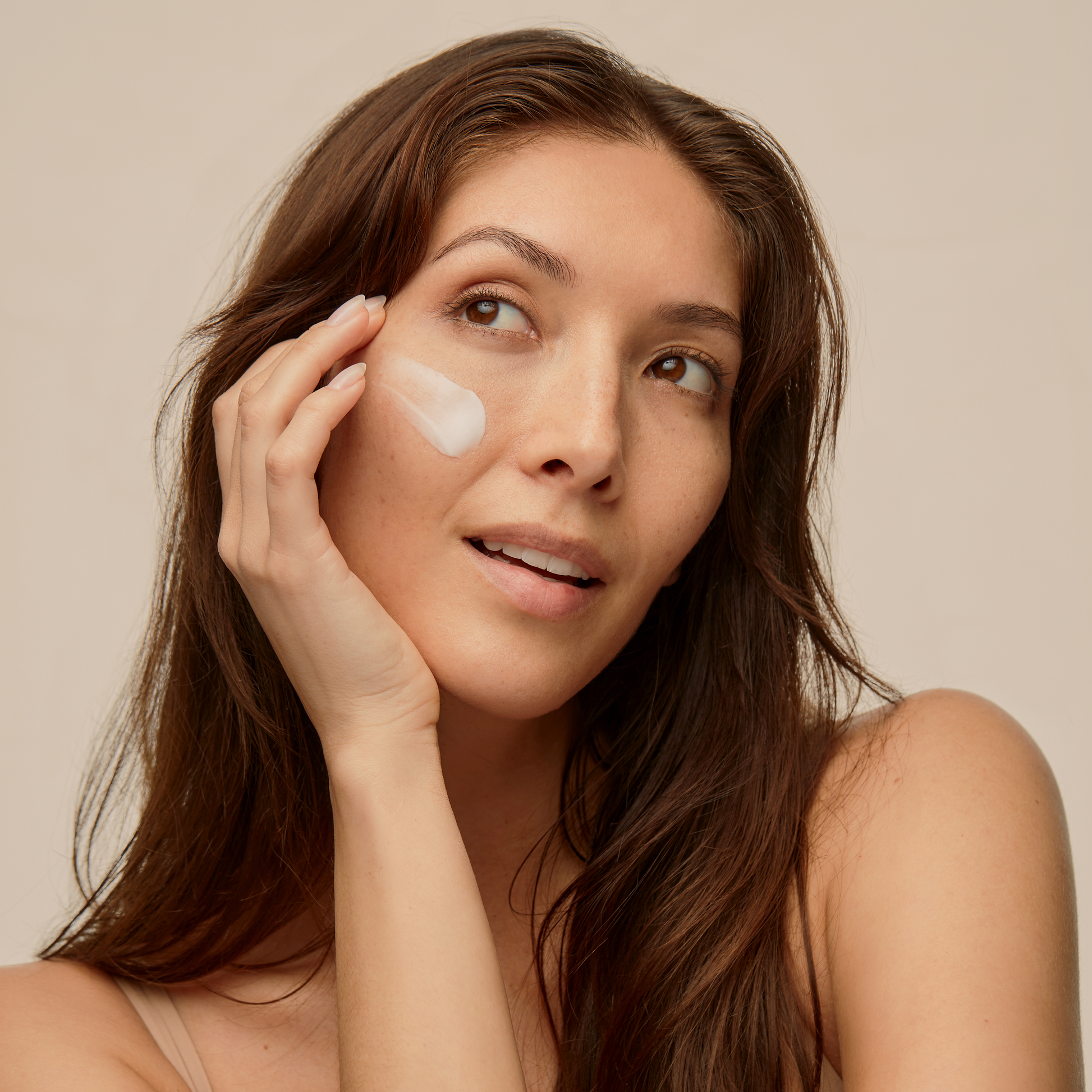 Woman applies best moisturizing Face Cream to prevent wrinkles and aging, made with moisturizing ingredients including glycerin and squalane. 