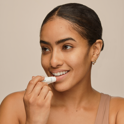 Woman  applying best natural, moisturizing lip balm for chapped lips 